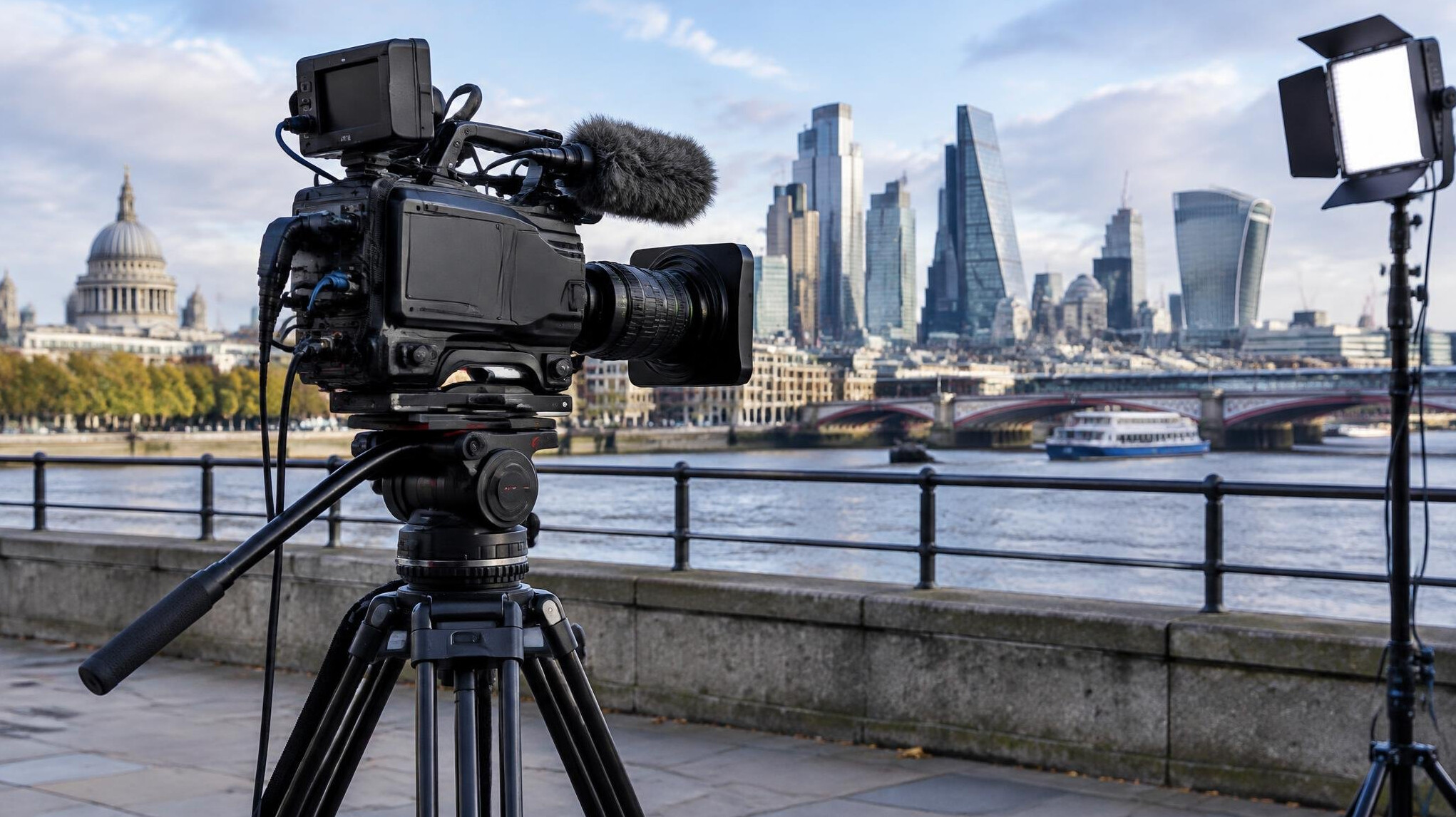 Camera on a tripod pointed at a city skyline