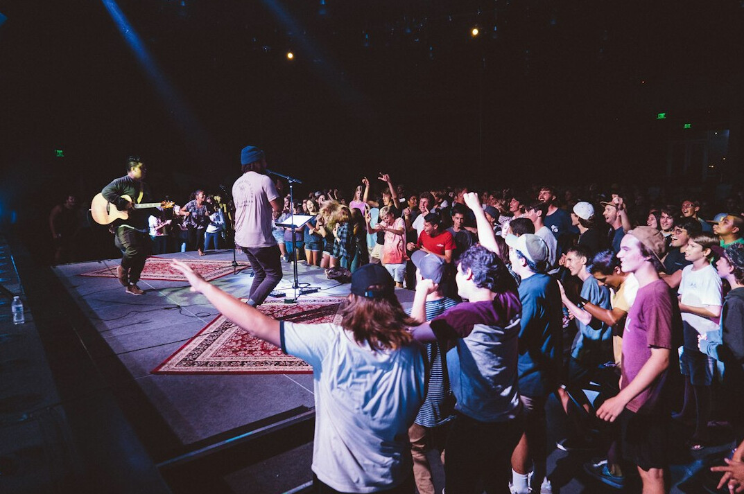 Live stage production with bright lights and crowd